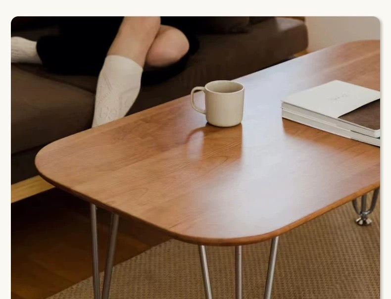 Wooden coffee table with a mug and book in a living room setting