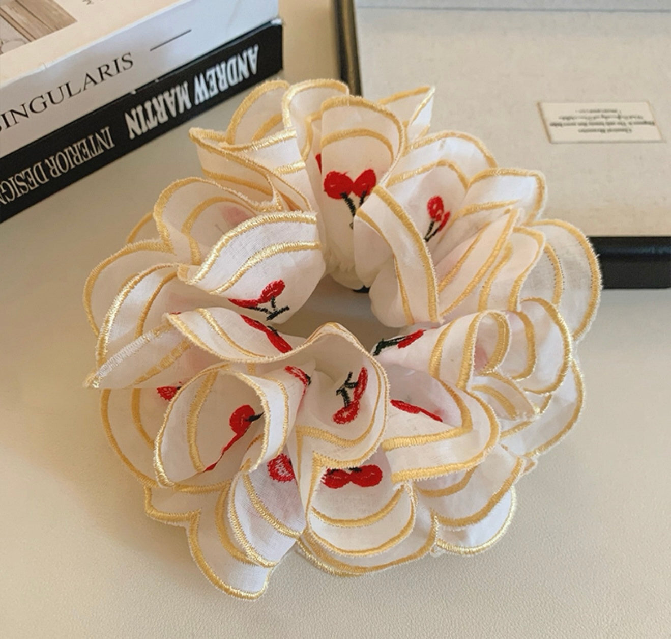 Decorative scrunchie with red and green accents on a neutral background
