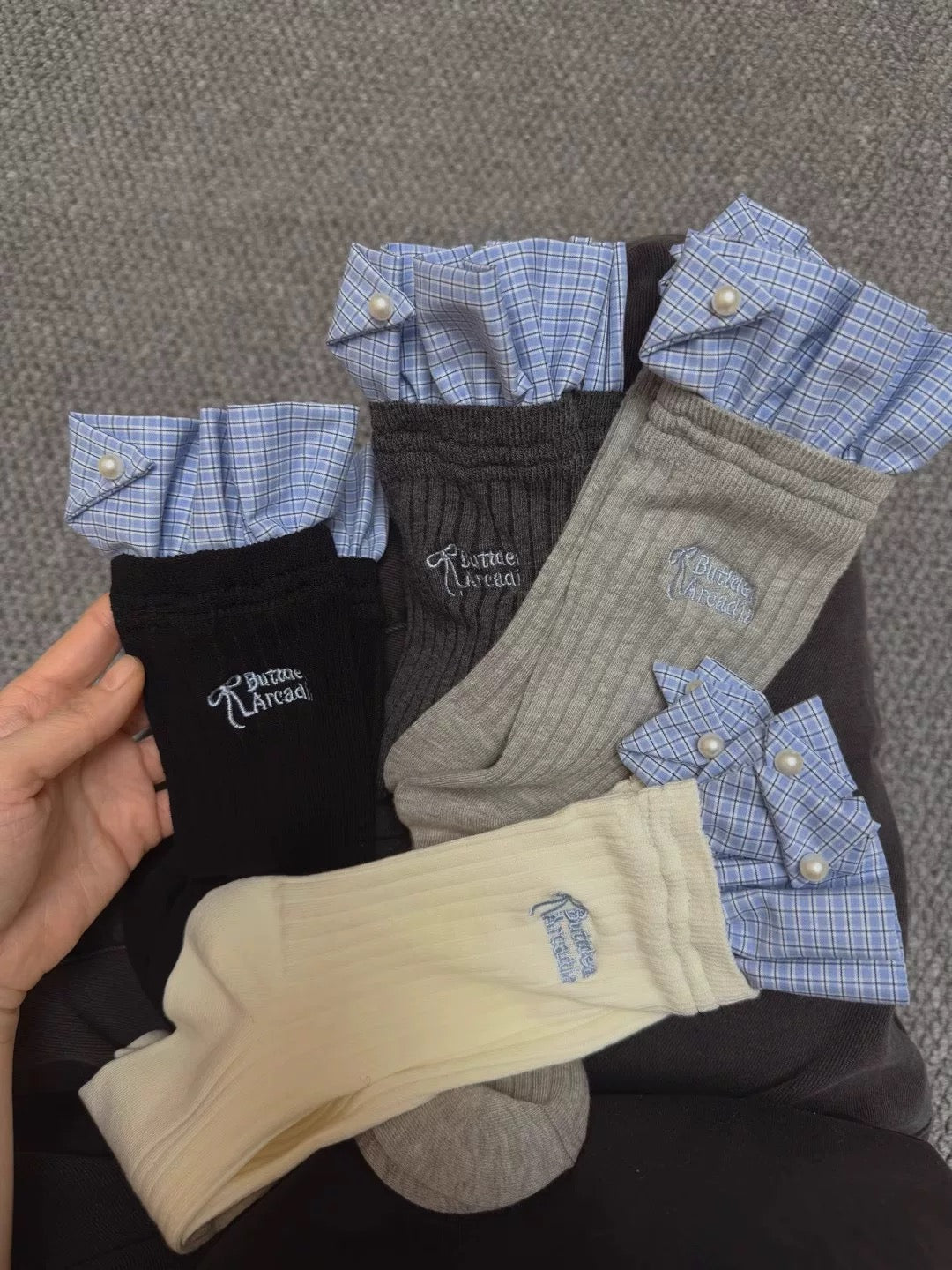Set of socks with ruffled cuffs and embroidered details on a gray background