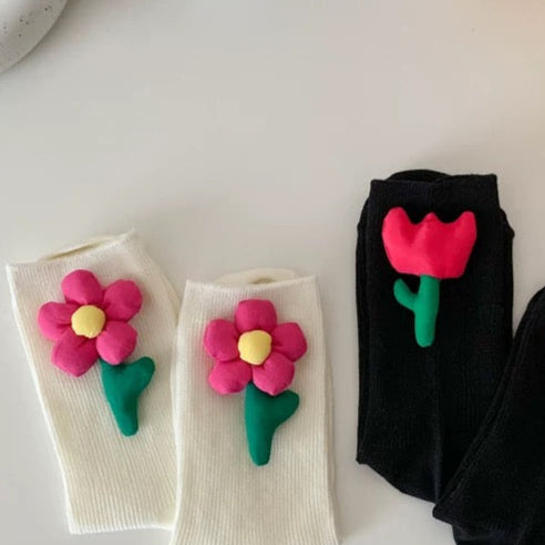 Two pairs of socks with floral designs on a white surface.