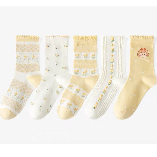 Set of five pairs of yellow and white socks on a white background