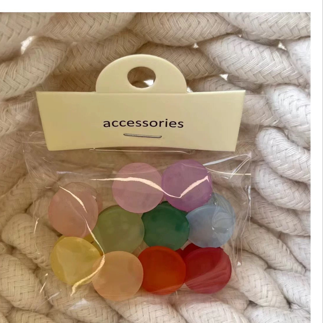 Packaged colorful accessories on a textured beige background