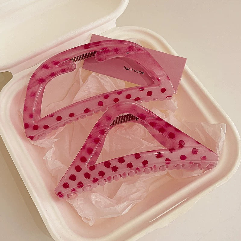 Pink dental aligner in a clear plastic case on a light pink background