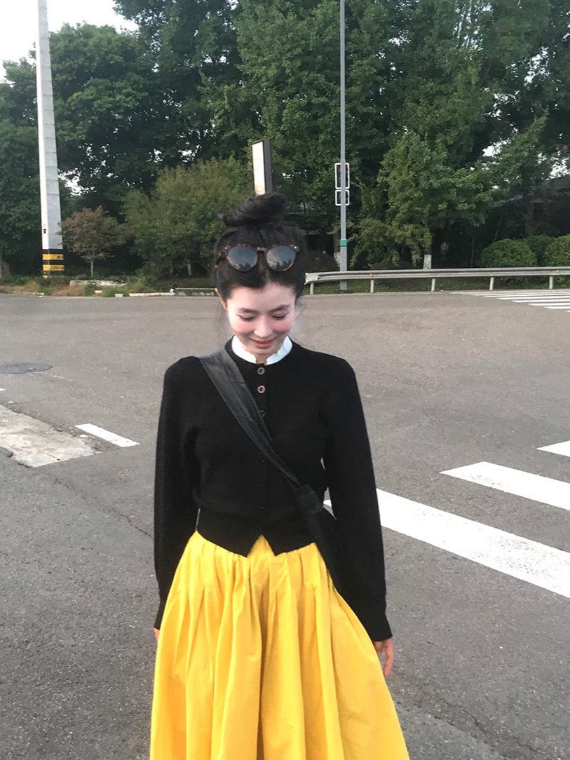 Person wearing a black top and yellow skirt on a road with 'VINONITA' branding.