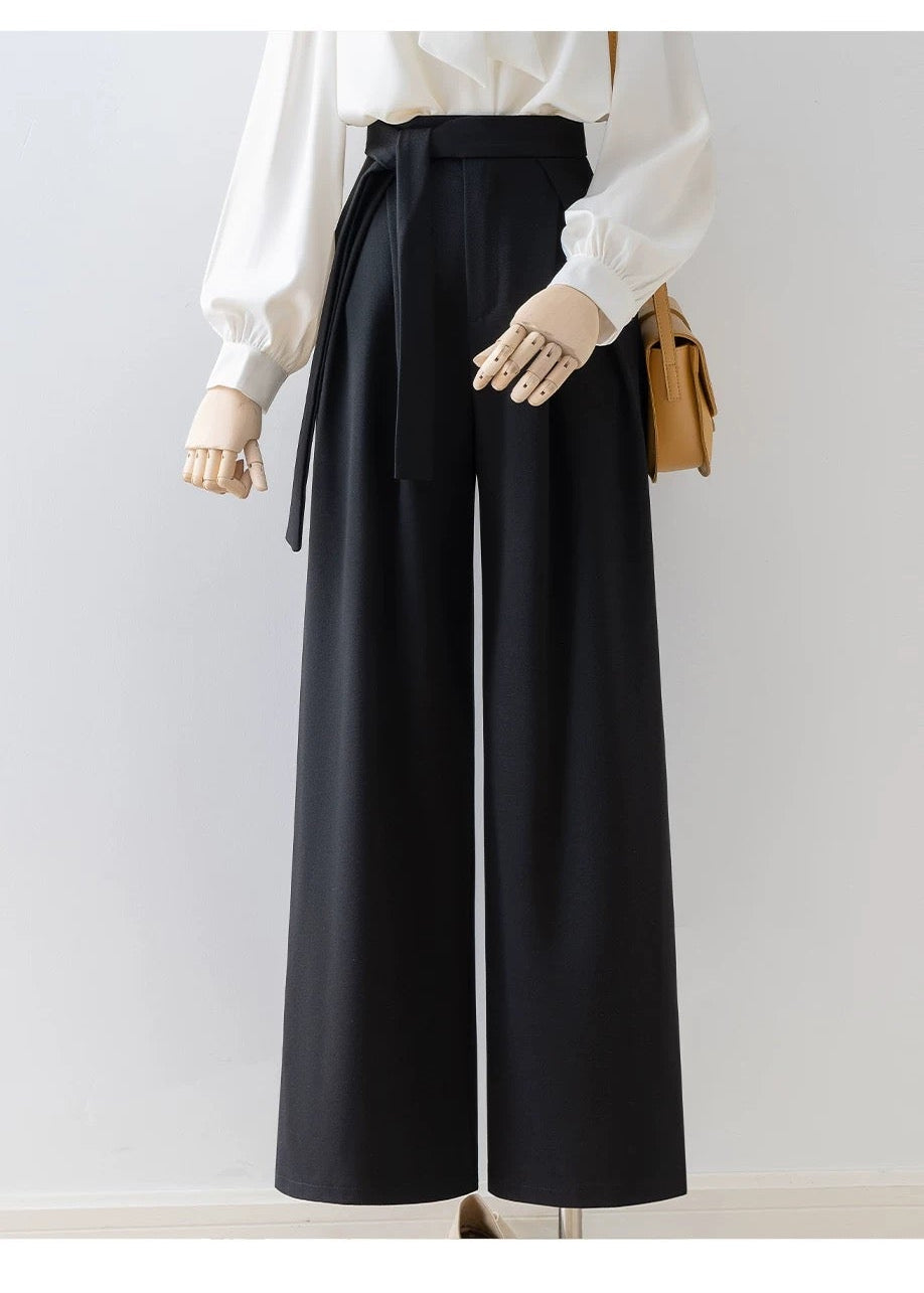 Person wearing a white blouse and black wide-leg pants on a plain background with 'Lush Summer Flower' branding.