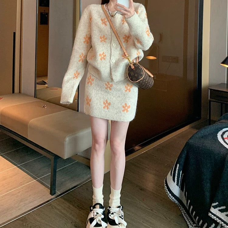 Person taking a mirror selfie wearing a light-colored floral dress and black sneakers in a modern interior setting.
