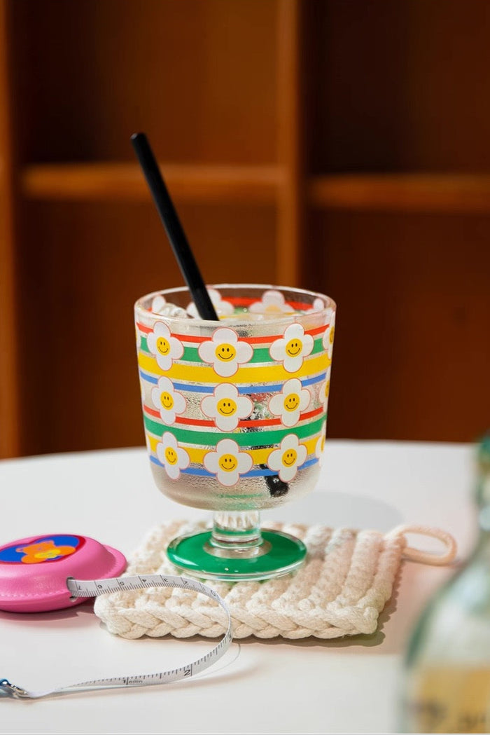 Colorful glass with floral pattern on a table with text '300ml 小酌刚刚好'.