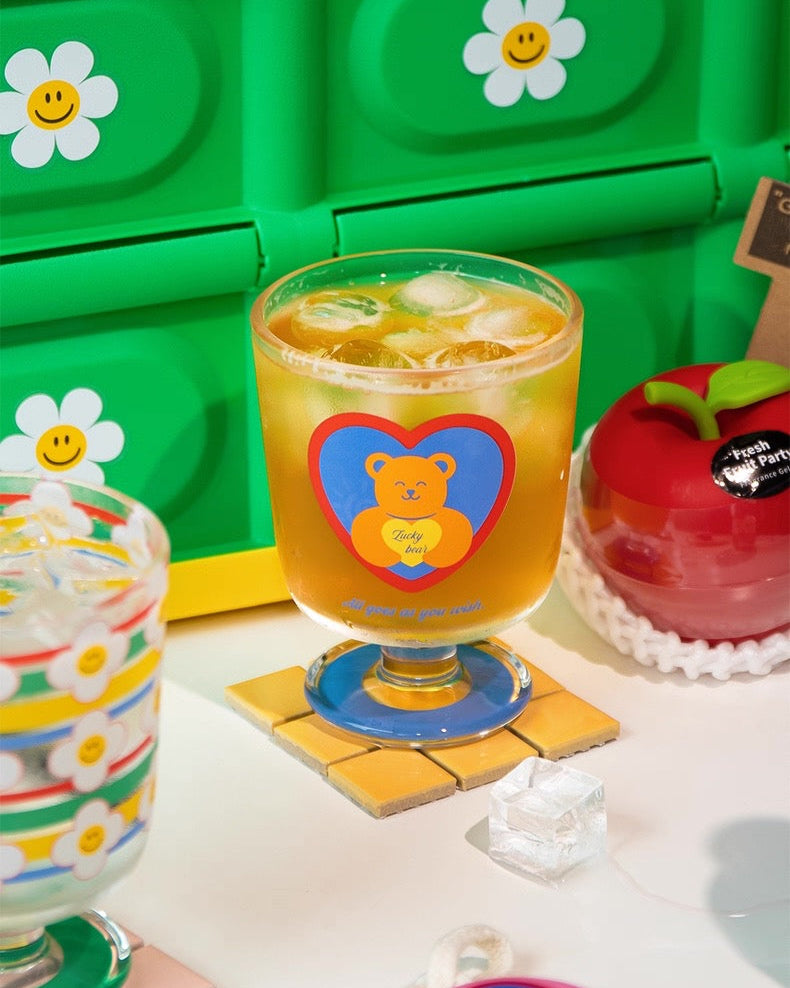 Colorful drink glasses with cartoon designs on a white surface