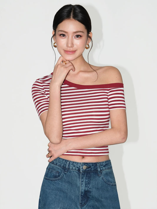 Woman wearing a red and white striped top and blue jeans against a white background