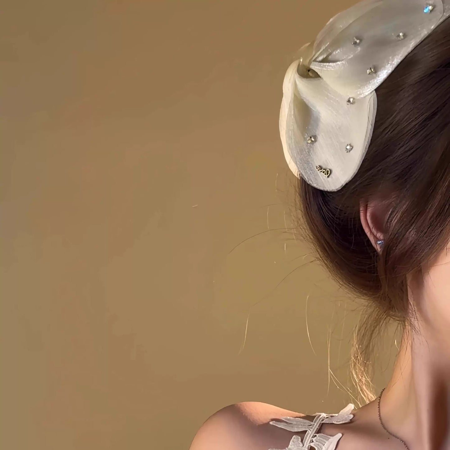 Person wearing a decorative headband with a plain background