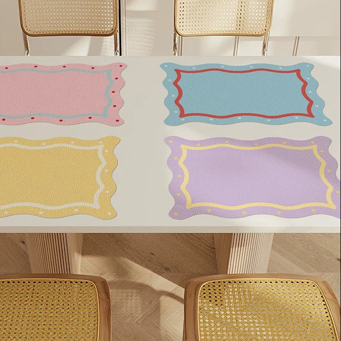 Colorful placemats on a table with wicker chairs in a minimalistic setting.