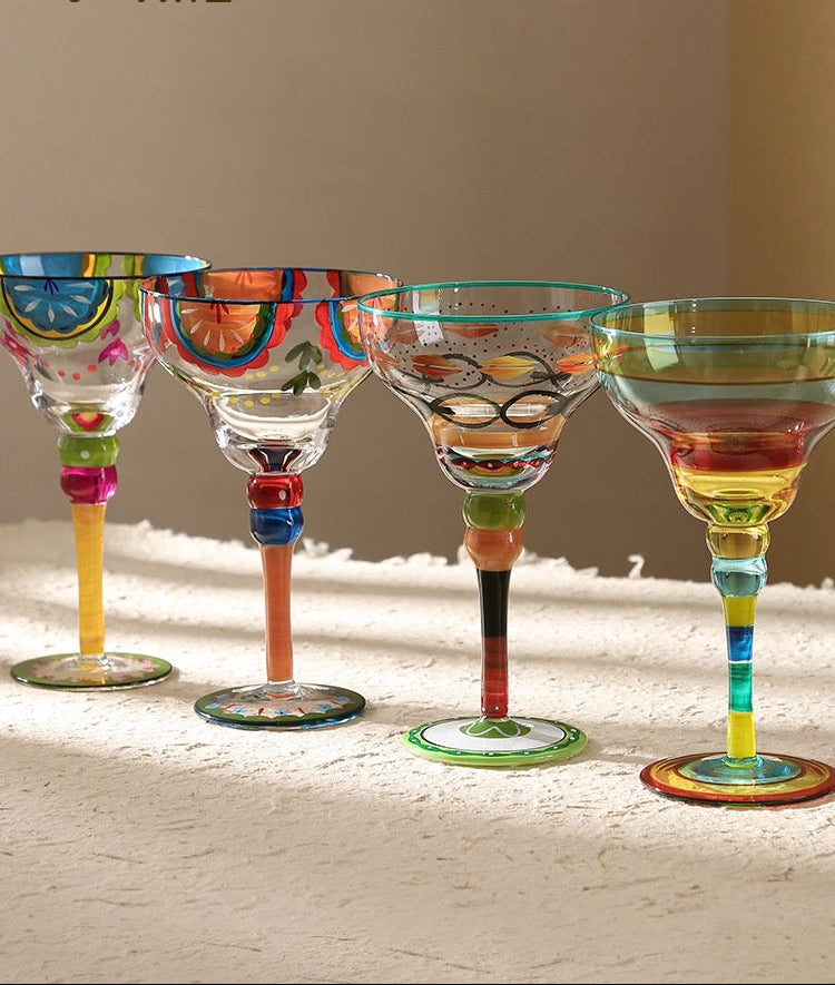 Set of colorful margarita glasses with branding on a neutral background