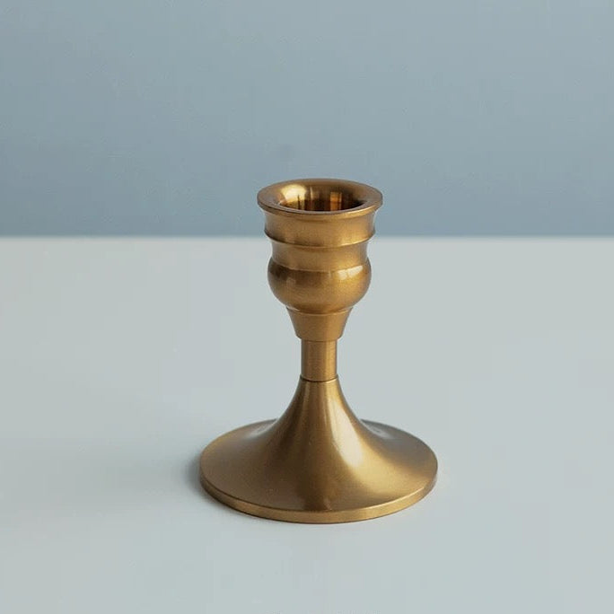 Gold candle holder on a light gray background