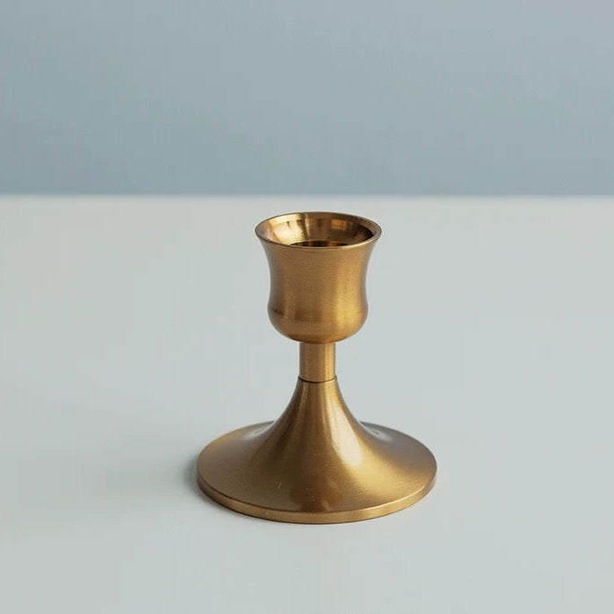 Gold candle holder on a light gray background