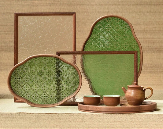 Decorative ceramic items with green patterns on a textured brown background