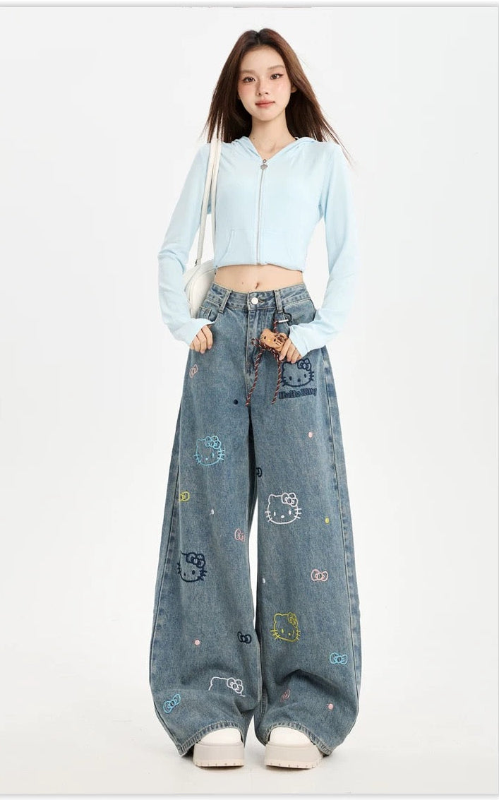 Woman wearing a light blue hoodie and patterned jeans on a white background
