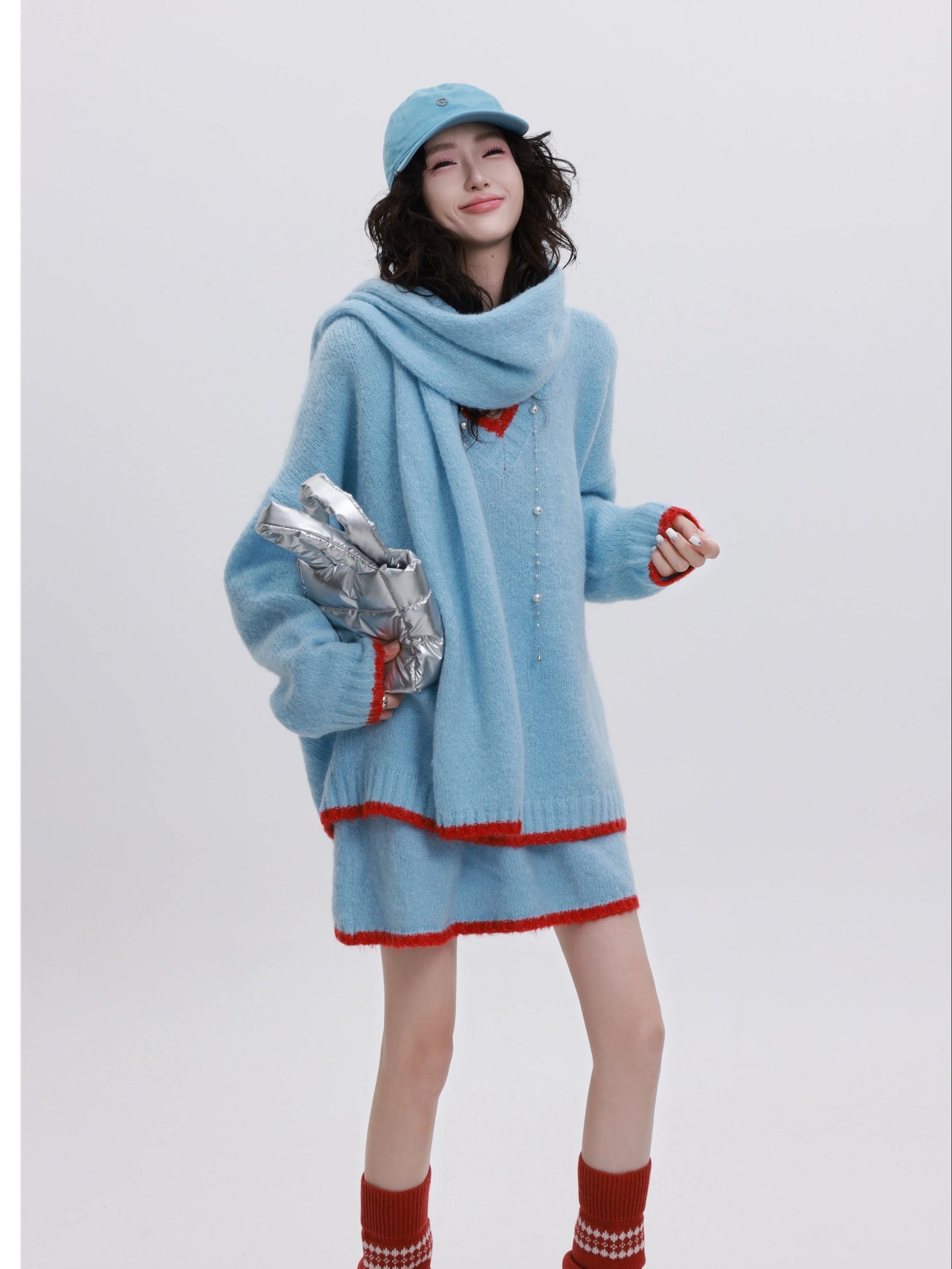 Woman wearing a light blue outfit with red accents, holding a bag, on a white background with text indicating 'YINGZI Collection' and '2025 SS New Arrival'.