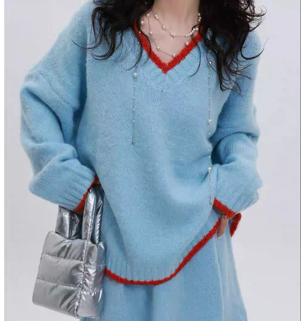 Person wearing a blue sweater dress with red trim holding a silver bag, labeled 'YINGZI COLECTION' on a white background.