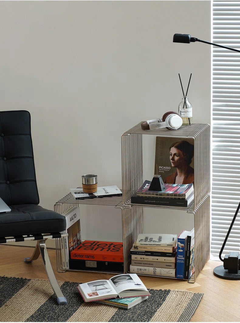 Modern side table with books, a cup, and a lamp in a room setting.