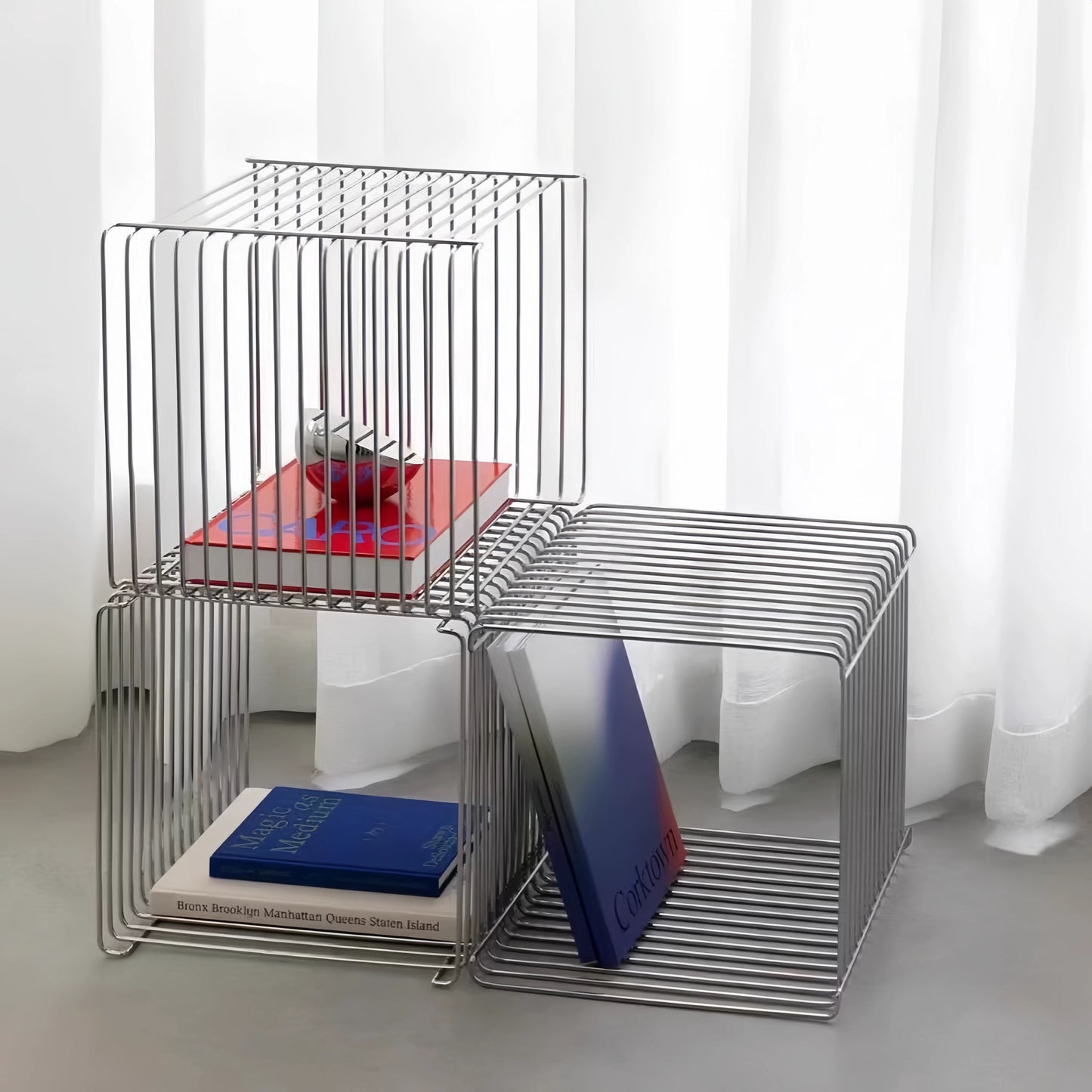 Metal side table with books on a white background