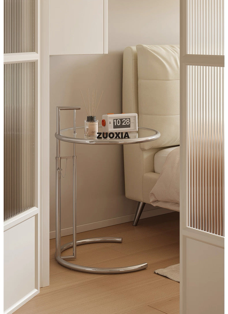 Glass side table with a lamp and decorative items in a bedroom setting, featuring the brand 'ZUOXIA'.