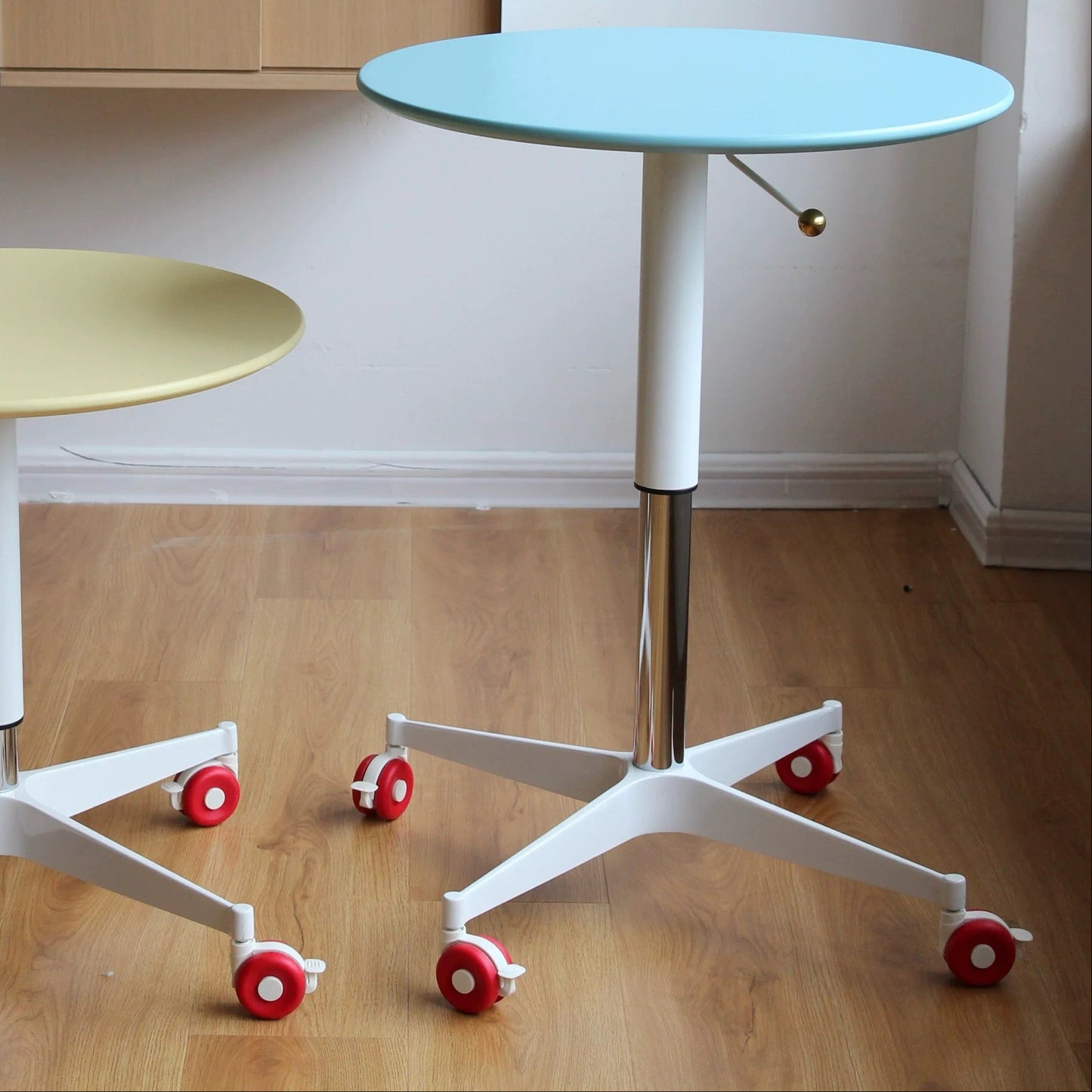 Two round tables with wheels on a wooden floor, with 'today home' branding.