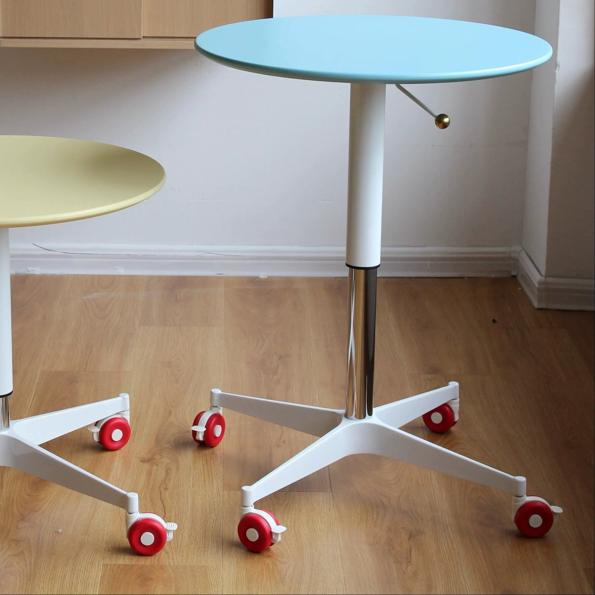 Two round tables with wheels on a wooden floor, with 'today home' branding.