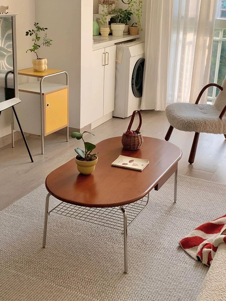 Living room with a wooden coffee table, potted plants, and a chair.