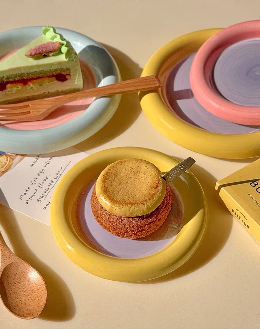 Slices of cake on plates with a spoon, on a light yellow background.