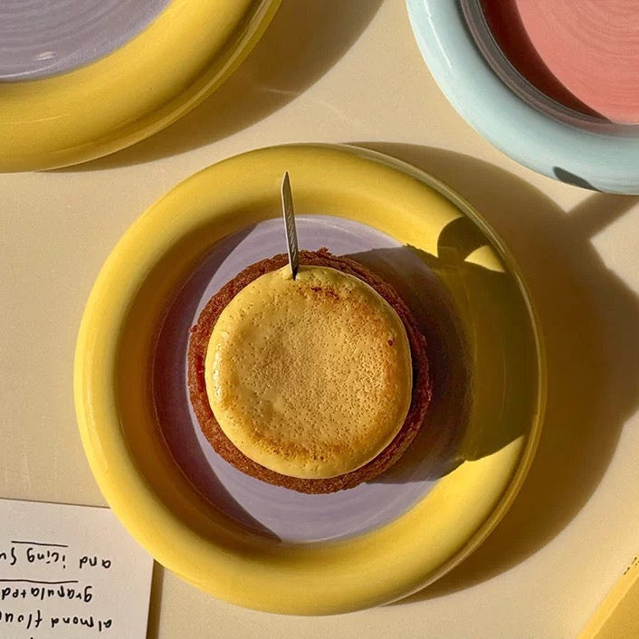 Small dessert on a yellow plate with a pink background