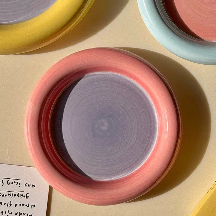 Color swatch with pink, yellow, and blue circular samples on a beige surface.