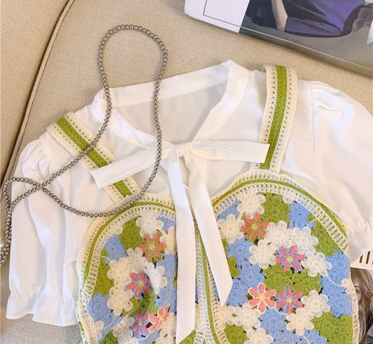 White blouse with floral embroidery on a beige surface