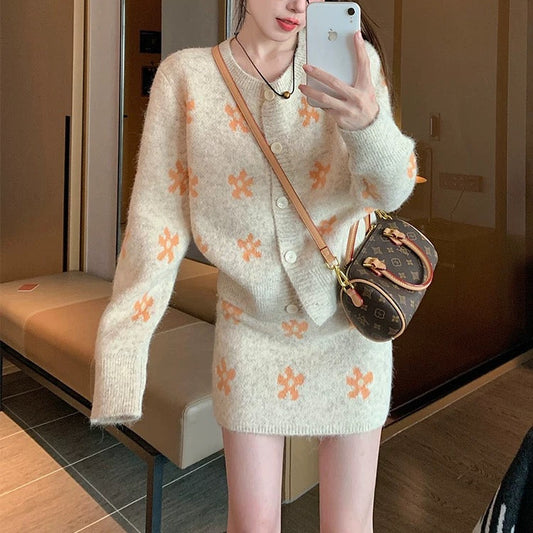 Woman taking a mirror selfie wearing a floral sweater and skirt set.