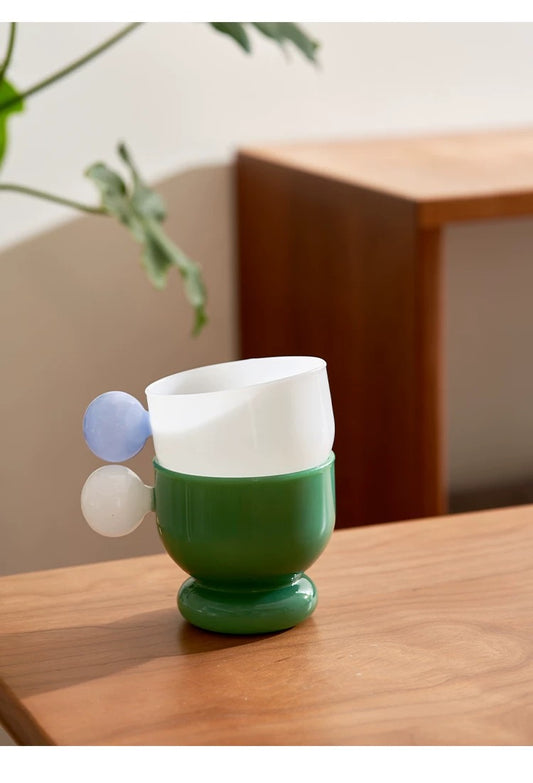 Green glass with white and blue accents on a wooden surface